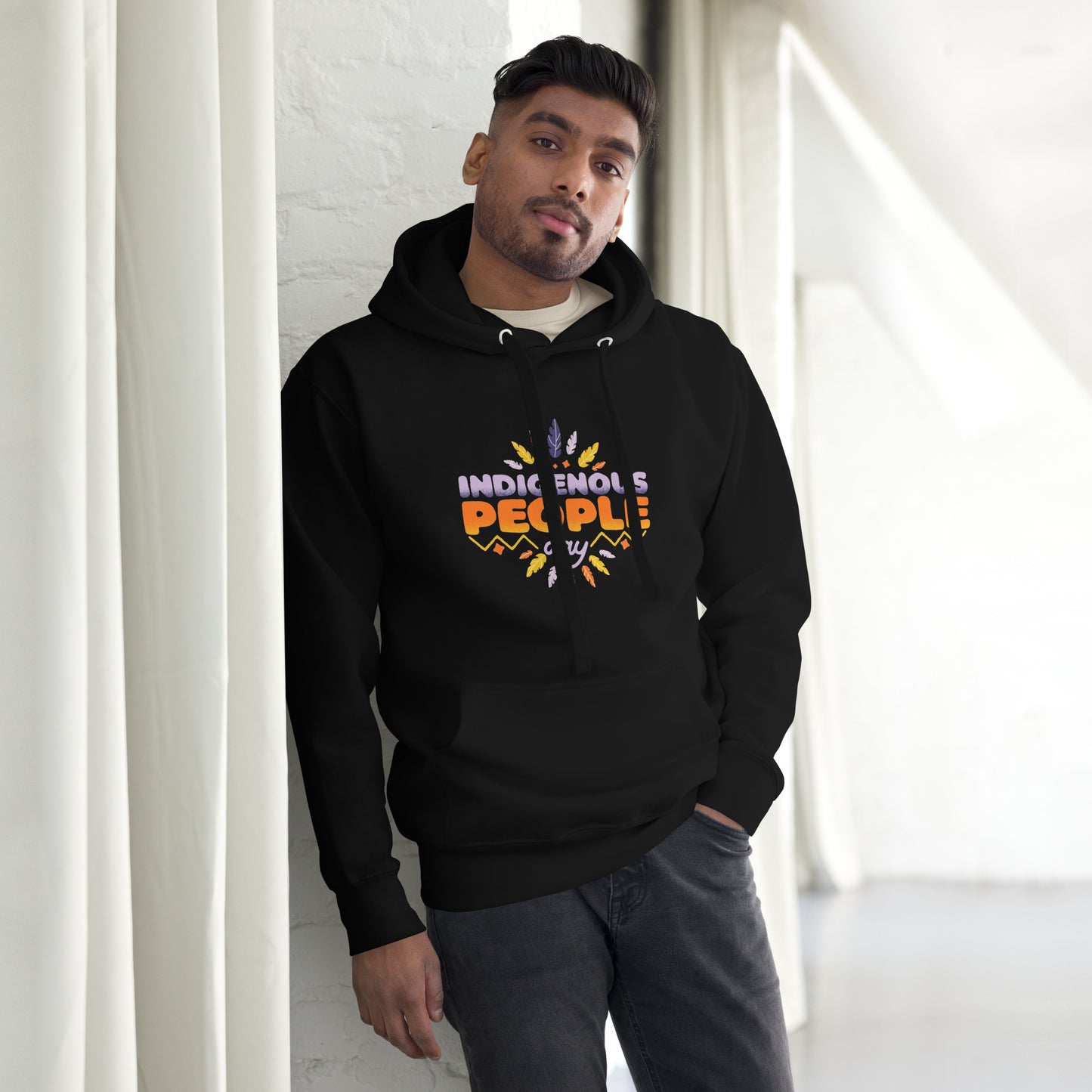 Male model leaning against a wall in a Black Hoodie